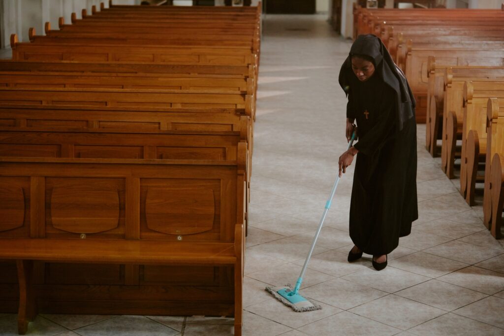 Young Black Nun Doing Chores In Church